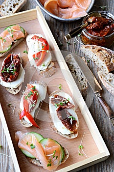 Toasts with salmon, dried tomatoes and sweet peppers