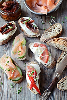Toasts with salmon, dried tomatoes and sweet peppers
