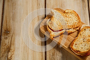 Toasts with sausage and cheese on a wooden stand. The concept of tasty and natural food.