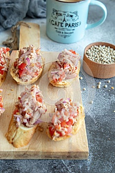 Toasts with tuna, tomatoes and pickled onion