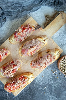 Toasts with tuna, tomatoes and pickled onion