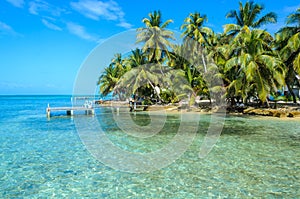 Tobacco Caye - Relaxing on Wooden Pier on small tropical island at Barrier Reef with paradise beach, Caribbean Sea, Belize,