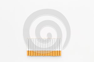 Tobacco. Row of cigarettes on white background top view copyspace