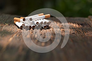 Tobacco cigarettes on wooden background with light shines on the