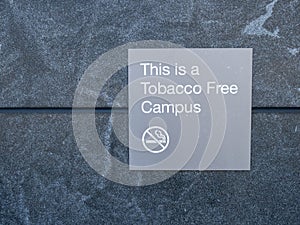 This is a tobacco free campus gray sign and logo posted outside of building