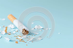 Tobacco Relinquished: Squashed Cigarette on Soft Blue.