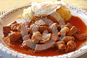 Tochitura is a traditional Romanian dish made from beef and pork served with eggs and polenta photo