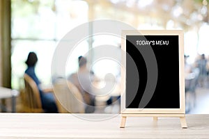 Todayâ€™s menu blackboard, sign board, on table at  blur coffee shop, restaurant, with people background, Blank chalkboard mock up