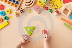 Toddler activity for motor and sensory development. Baby hands with different colorful wooden toys on table top view