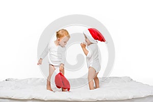 toddler asian boy and caucasian girl with santa hats