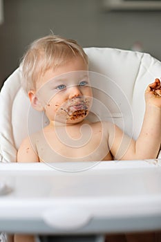 Toddler baby boy child eating fruit with dirty messy face