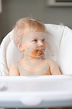 Toddler baby boy child eating fruit with dirty messy face