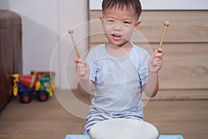 Toddler baby boy child hold sticks & plays a musical instrument drum