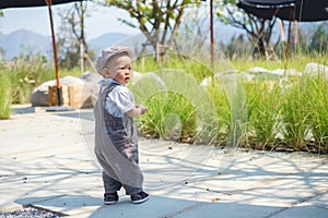 Toddler baby boy walking, baby`s first steps concept