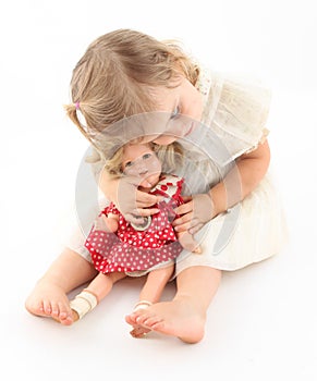 Toddler baby girl snuggling her precious doll