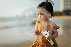 toddler baby girl standing on sea beach