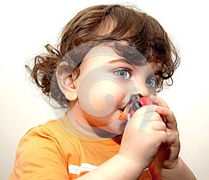 Toddler baby holding a toy so blue eyes long eyelashes