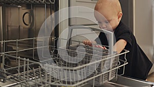 toddler baby kid black shirt playing opened dishwasher touching plastic bin