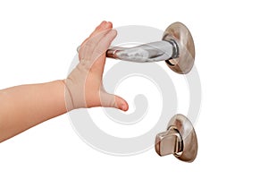 Toddler baby opens the door holding the door handle, child hand close-