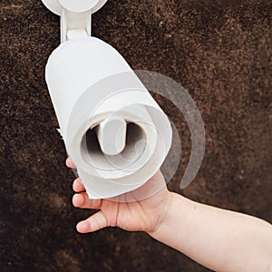 Toddler baby reaches for toilet paper, child s hand with hygiene produc