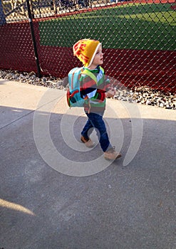 Toddler Boy with a Backpack leaving the Baseball Game