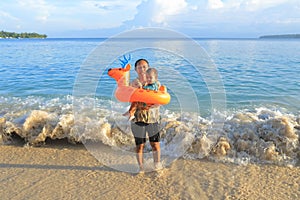 Toddler boy carried by mom from sea