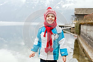 Toddler boy, child, standing on the edge of the lake in Hallstadt, Austria