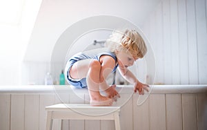 Toddler boy in a dangerous situation in the bathroom.