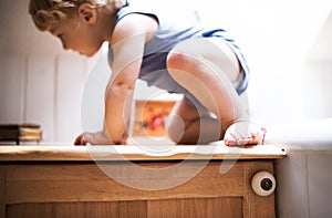 Toddler boy in a dangerous situation in the bathroom.