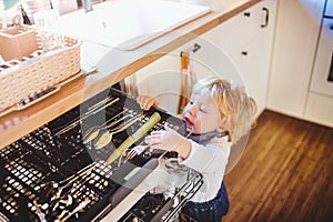 Toddler boy in dangerous situation at home. Child safety concept.