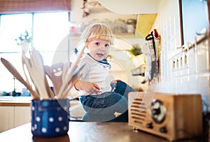 Toddler boy in dangerous situation at home. Child safety concept.