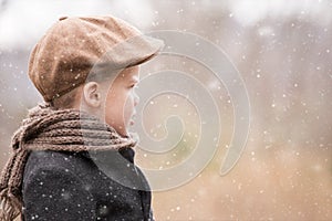 A toddler boy dressed warm looking ahead and photo