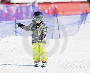 Toddler Boy Dressed Warmly & in Good Safety Gear Skiing Downhill