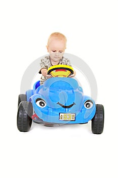 Toddler boy driving a toy car