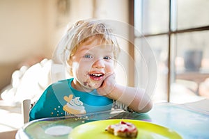 A toddler boy eating at home.