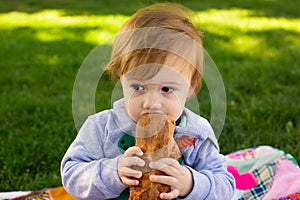 Toddler boy eats loaf of bread