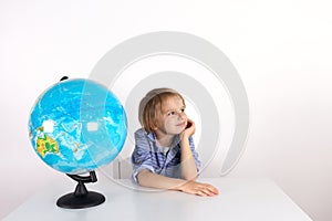 Toddler boy with a globe on the lesson of practical life on a white background, Montessori class, isolate. photo