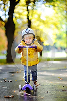 Toddler boy in helmet to ride scooter