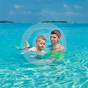 Toddler boy learns to swim with father