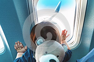 Toddler boy looking out a plane window