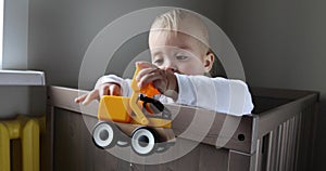 Toddler boy playing with colorful toy tractor