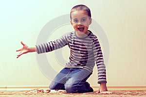 Toddler boy is playing in the house on the floor. A kid boy playing toy blocks inside his house. Happy little boy. Smiling child