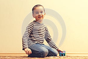 Toddler boy is playing in the house on the floor. A kid boy playing toy blocks inside his house. Happy little boy. Smiling child