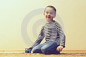Toddler boy is playing in the house on the floor. A kid boy playing toy blocks inside his house. Happy little boy. Smiling child