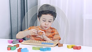 Toddler boy playing indoors with educational toy.