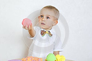 A toddler boy playing with kinetic pasticine, a great activity to develop fine motor skills