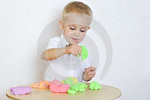 A toddler boy playing with kinetic pasticine, a great activity to develop fine motor skills