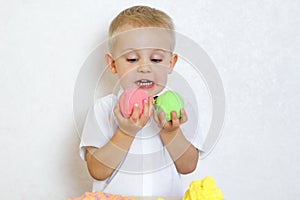 A toddler boy playing with kinetic pasticine, a great activity to develop fine motor skills