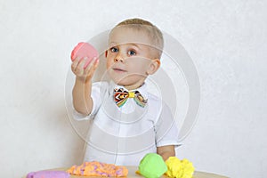 A toddler boy playing with kinetic pasticine, a great activity to develop fine motor skills