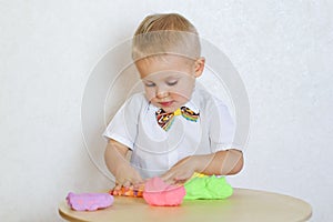 A toddler boy playing with kinetic pasticine, a great activity to develop fine motor skills